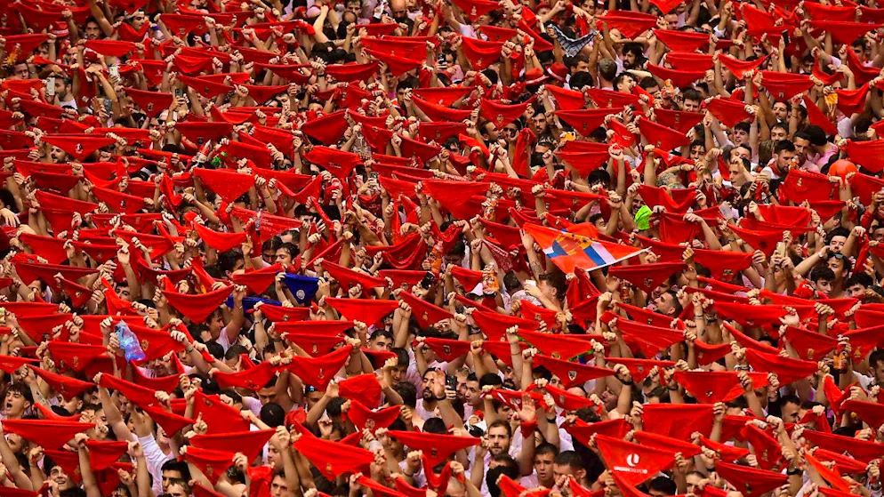 Revelers hold up red scarves as they crowd the main square at the start of nine days of continuous celebrations for the famous bull-running festival. Photo: Alvaro Barrientos/AP/dpa