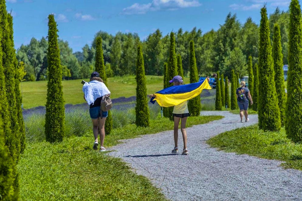 Blooming splendor in dark times: Kiev defies the hardships of war. A girl uses a flag to protect herself from the sun: Dobro Park is a 150-hectare garden that was affected by the war and has been restored.