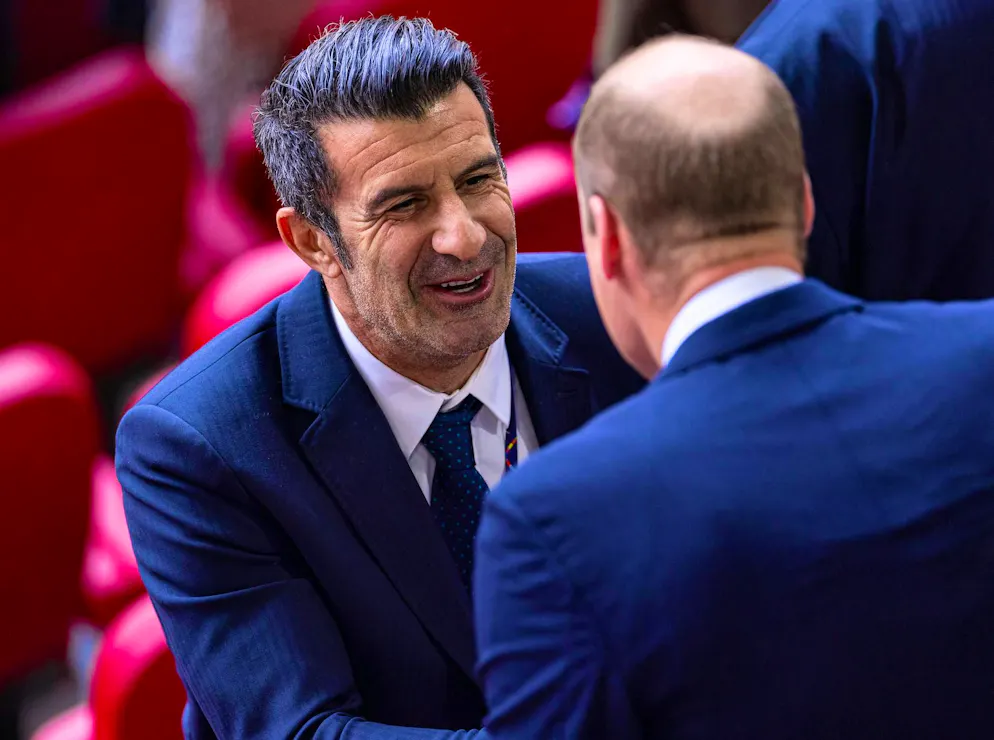 Prince William at the England-Switzerland match. Prince William and Luis Figo, former Portuguese professional footballer, find time to chat after the match.