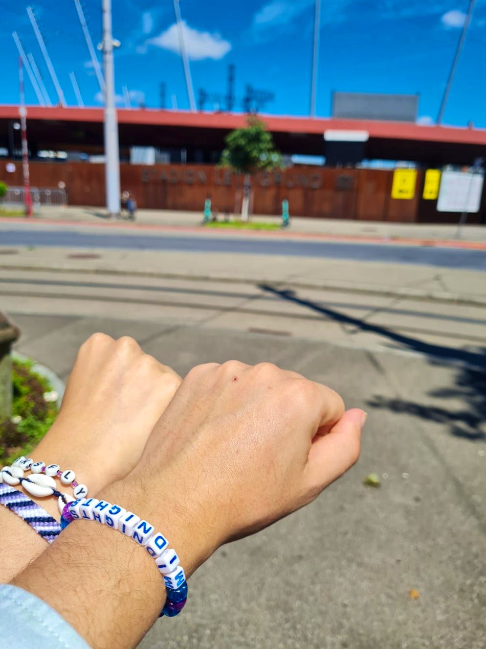 Zwei Swifties posieren am Tag vor dem Konzert mit Armbändern vor dem Letzigrund.