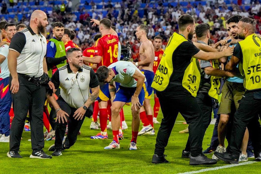 Alvaro Morata (al centro) si tocca la gamba dopo essere stato travolto da uno steward.