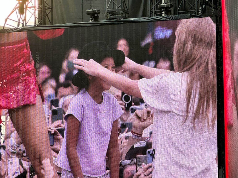 Taylor Swift verschenkt ihren Hut an einen kleinen Fan.