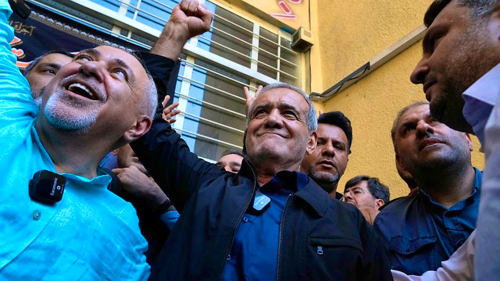 ARCHIVE - Reform candidate for the Iranian presidential elections, Massud Peseschkian (M), clenches his fist after casting his vote at a polling station in Shahr-e-Qods near Tehran. He is accompanied by former Foreign Minister Mohammed Jawad Sarif, left. Photo: Vahid Salemi/AP/dpa