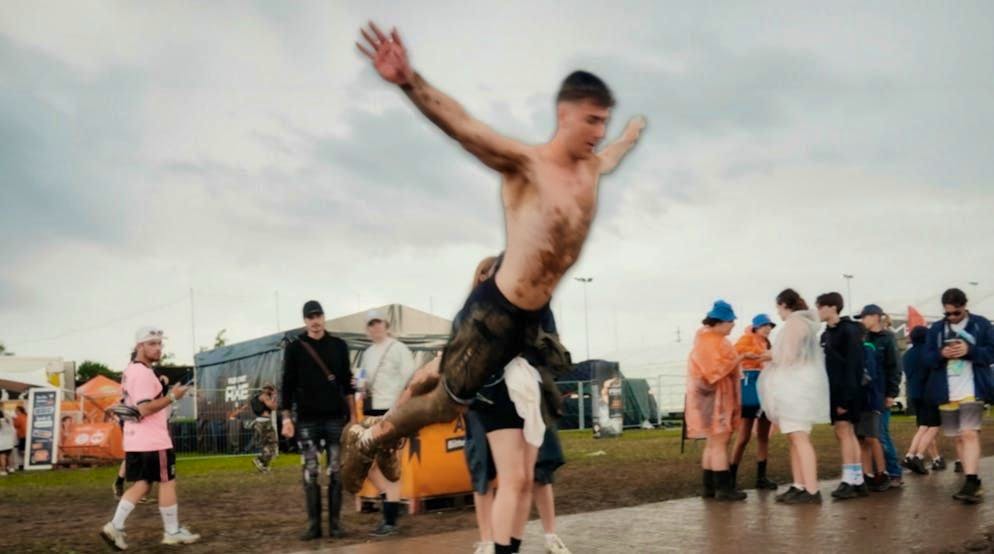 On Friday, a visitor jumps belly-first into the mud after losing a bet.