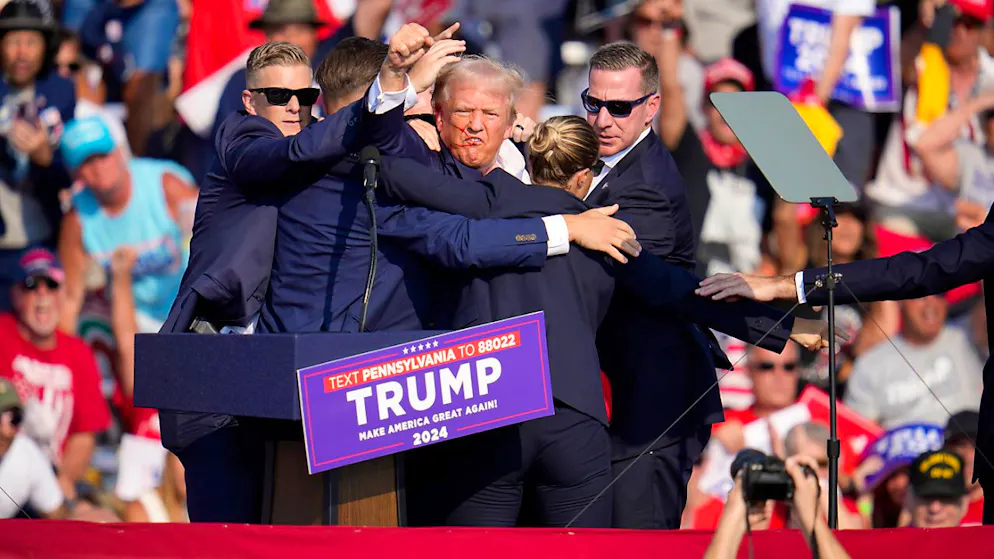 Agenten des US-Geheimdienstes Secret Service schützen den republikanischen Präsidentschaftsbewerber und ehemaligen US-Präsidenten Donald Trump auf der Bühne bei einer Wahlkampfveranstaltung in Butler, Pennsylvania. Foto: Gene J. Puskar/AP/dpa