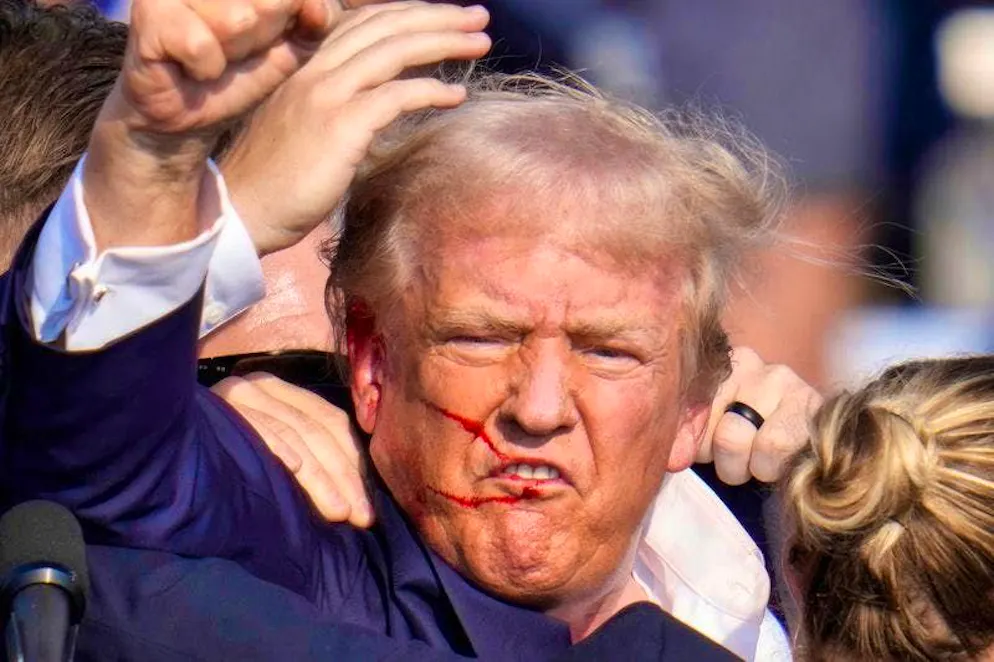 Republican presidential candidate and former US President Donald Trump gestures as he is surrounded by agents of the US Secret Service.