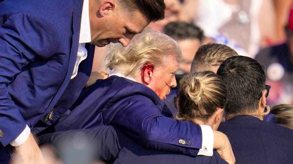 Attacco a Trump durante la campagna elettorale statunitense. Il personale di sicurezza aiuta Donald Trump a scendere dal palco.