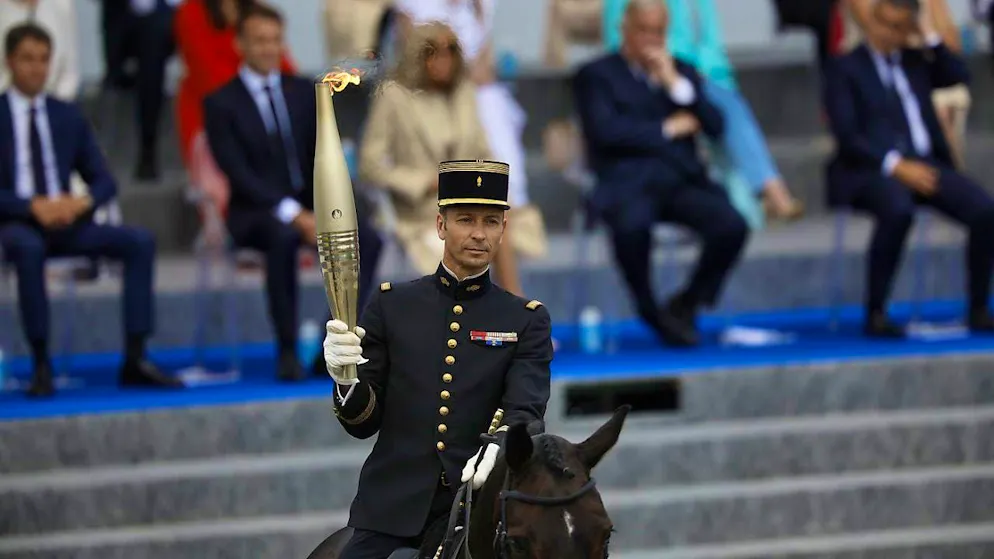 Thibaut Vallette, head of the French elite equestrian school Cadre Noir, receives the Olympic flame in Paris on Sunday