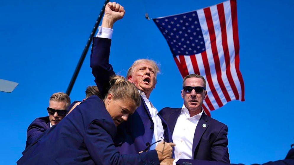 Attack on Trump during US election campaign - suspected shooter dead - Gallery. Republican presidential candidate Donald Trump, bleeding from the ear, is brought to safety by Secret Service agents. (July 13, 2024)