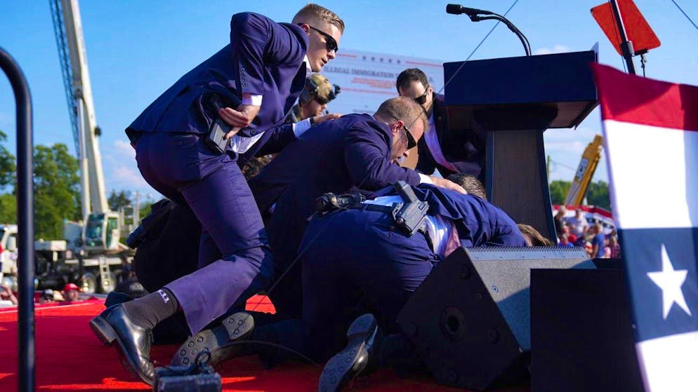 Attack on Trump during US election campaign - suspected shooter dead - Gallery. Donald Trump ducks away and is protected by Secret Service agents.