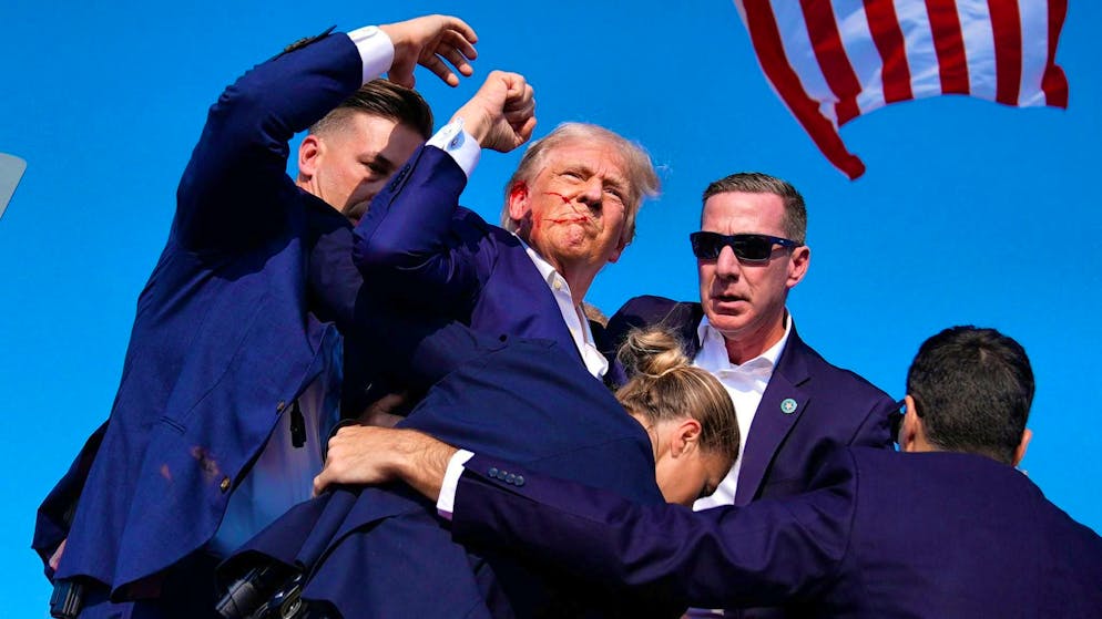 Attack on Trump during US election campaign - suspected shooter dead - Gallery. Trump is escorted off the stage by security personnel.