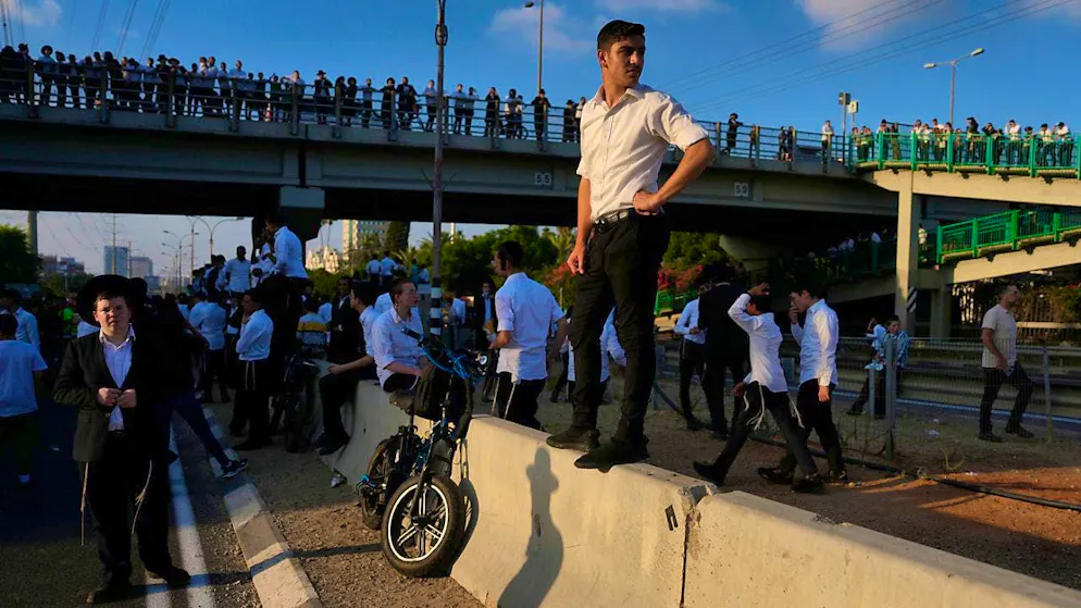 Ultra-Orthodox Jewish youths block a street to protest against military recruitment. Photo: Ohad Zwigenberg/AP/dpa