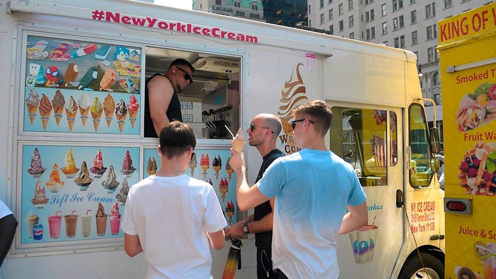 Menschen bestellen während der dritten Hitzewelle des Sommers in Manhattan Eis an einem Eiswagen. Foto: Jimin Kim/SOPA/ZUMA/dpa