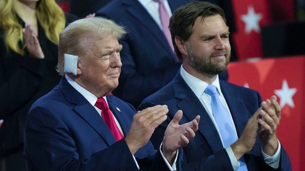 Beim ersten Tat des republikanischen Parteitags in Milwaukee: Der nunmehr offizielle Präsidentschaftskandidat der Republikaner, Donald Trump (l.), mit seinem Vizekandidaten J.D. Vance und einem Verband am rechten Ohr, das am Samstag bei einem versuchten Attentat leicht verletzt wurde. (15. Juli 2024)