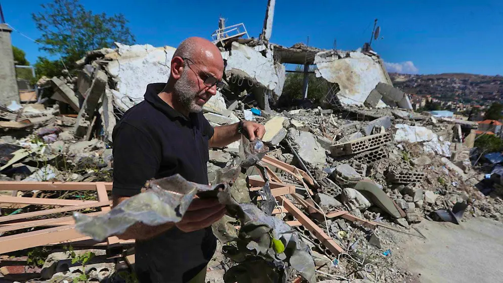 A man shows the remains of a missile from an Israeli warplane that hit a house, killing a Hezbollah fighter and two of his civilian family members. Photo: Mohammad Zaatari/AP/dpa