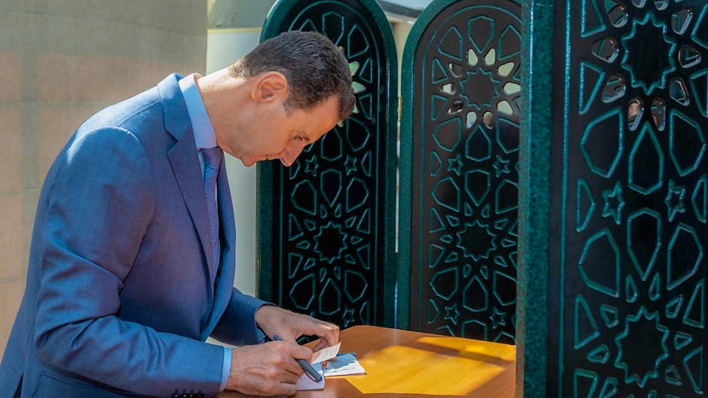 HANDOUT - Der syrische Präsident Baschar al-Assad füllt seinen Stimmzettel vor der Stimmabgabe bei den Parlamentswahlen 2024 aus. Foto: -/SANA/dpa