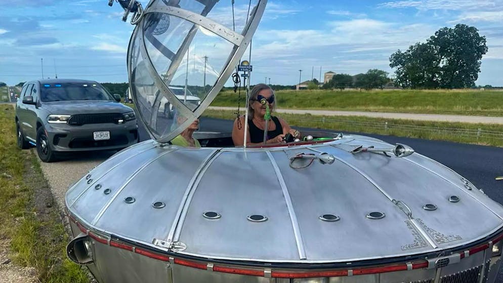 Driving UFO. Police officer checks alien on the highway