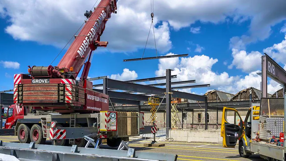 A pneumatic crane is used to carefully remove the steel beams from the old Basel bus garage so that they can be reused.