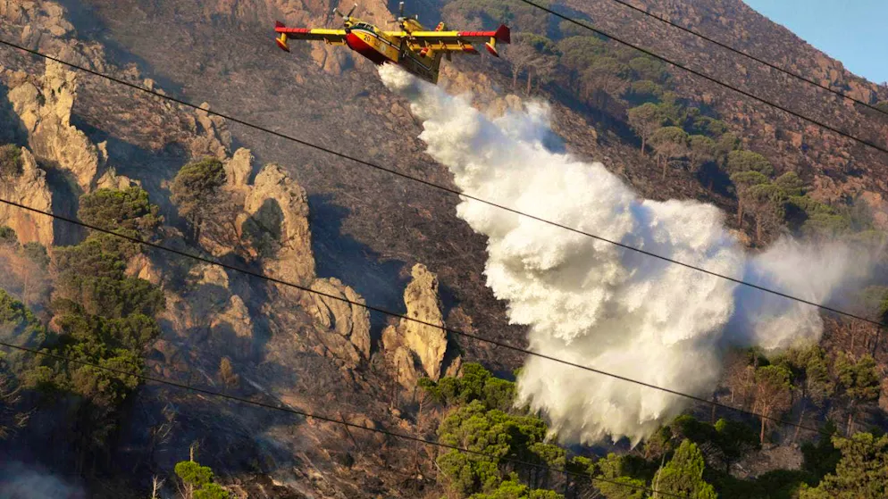 ARCHIVE - A fire-fighting plane drops water over a forest fire in Sicily. Photo: Alberto Lo Bianco/LaPresse/AP/dpa
