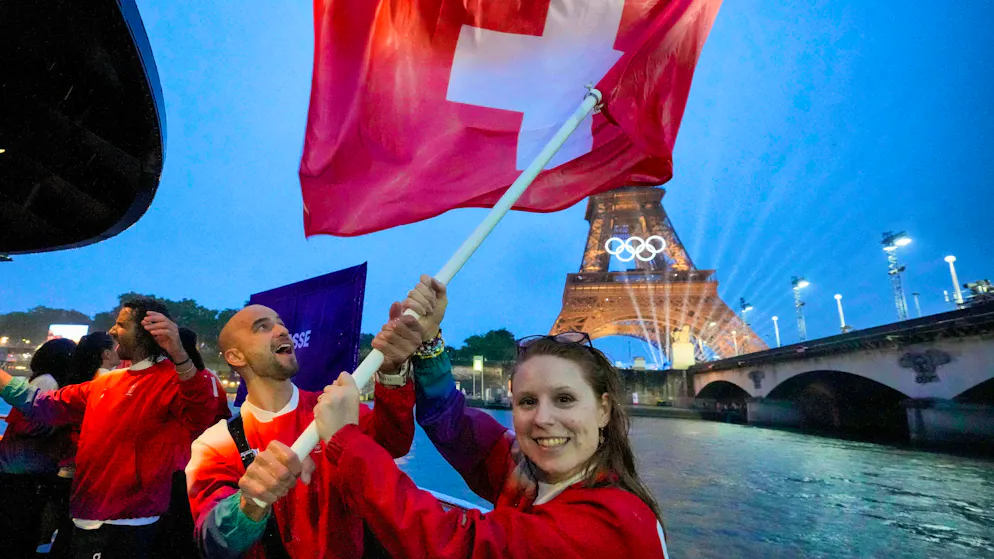 Olympic Opening Ceremony. Nino Schurter and Nina Christen with the Swiss flag.