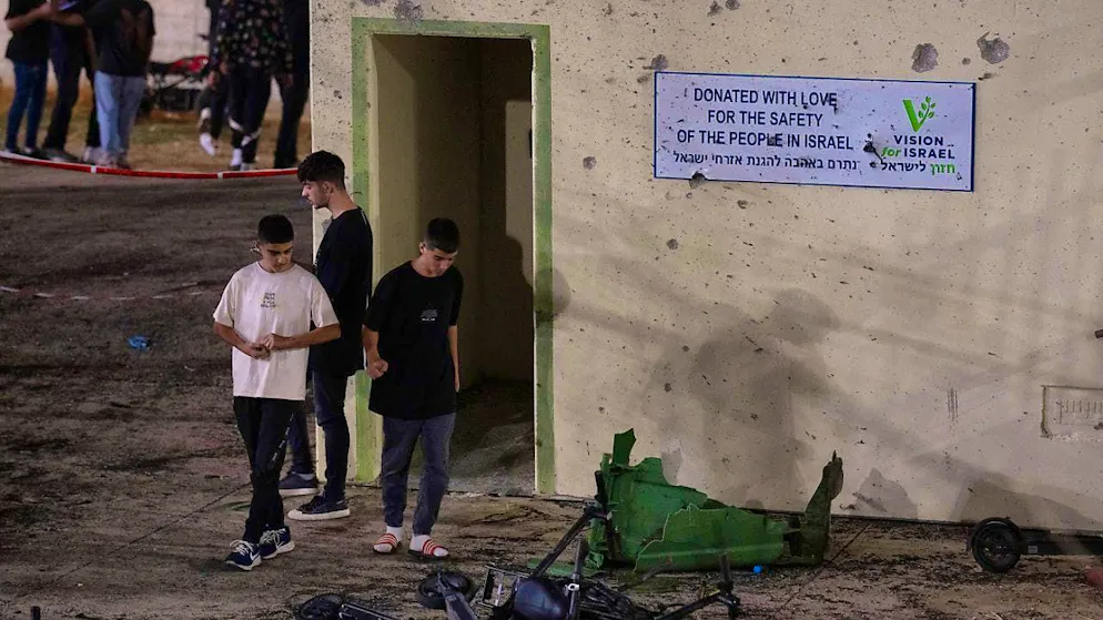 Youths walk next to a shrapnel-damaged shelter on a soccer field that was hit by a rocket in the Druze town of Majd al-Sham in the Golan Heights annexed by Israel. Photo: Leo Correa/AP/dpa
