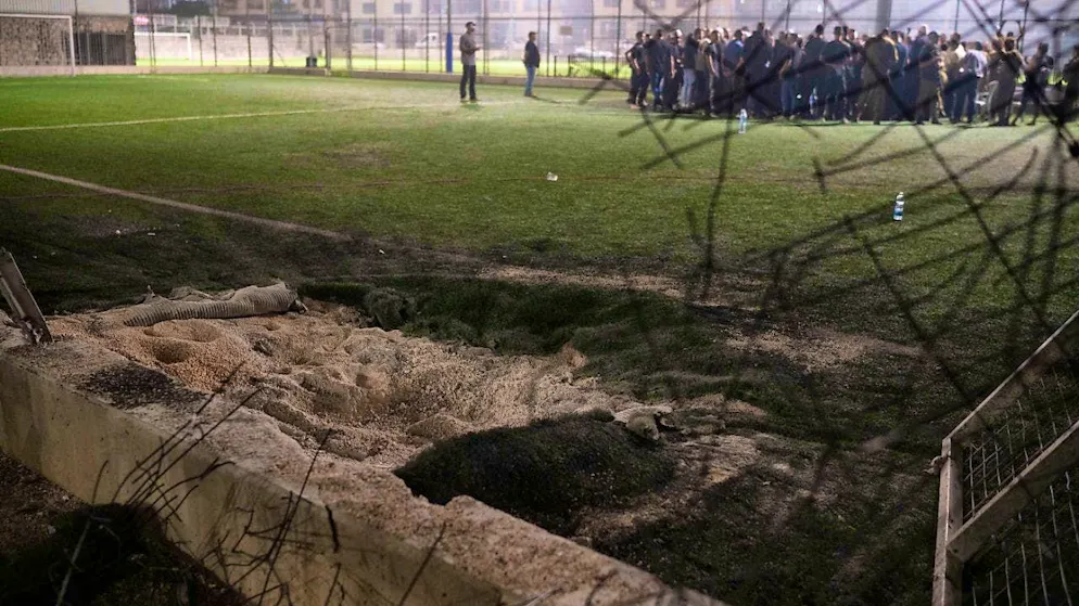 Residents gather with authorities at a soccer field in the town of Majd al-Sham in the Israeli-occupied Golan Heights, which was hit by a rocket that killed several children and teenagers. Photo: Leo Correa/AP/dpa