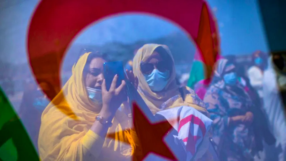 ARCHIVE - Saharan demonstrators stand behind a Western Sahara flag during a protest in support of the head of the Polisario independence movement in Western Sahara at La Concha beach. Photo: Alvaro Barrientos/AP/dpa