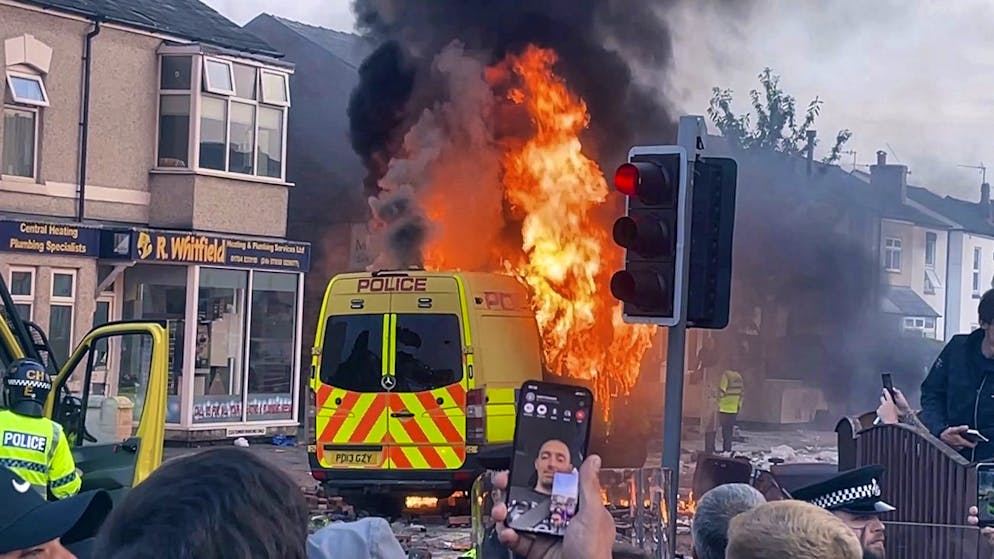 Krawalle nach Bluttat in England – 39 Polizisten verletzt - Gallery. Ein Polizeiwagen geht in Flammen auf.