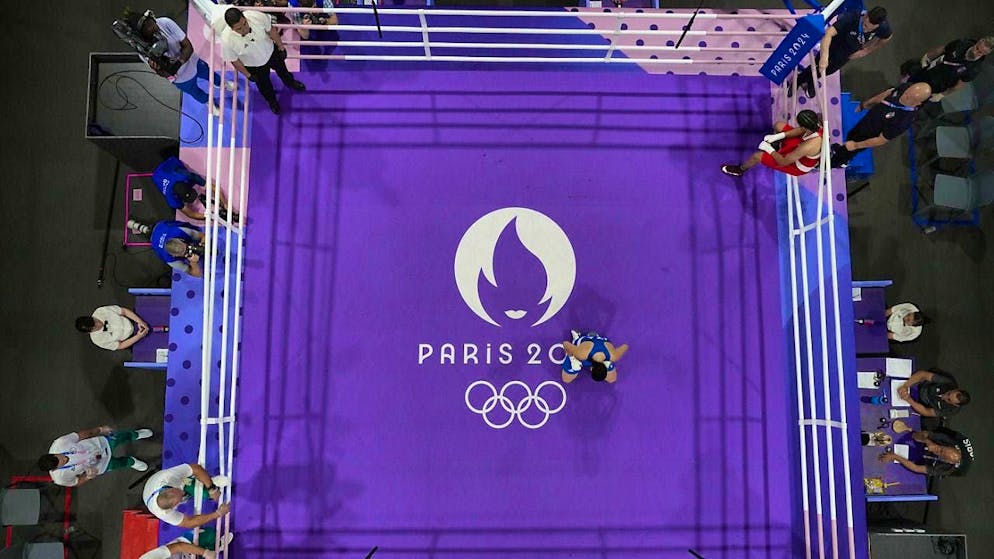 Angela Carini in the center kneels after losing the fight against Imane Khelif.