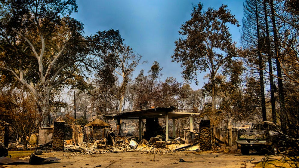 A house and truck lie in ruins after the wildfire swept through a residential neighborhood in Butte County, Calif.