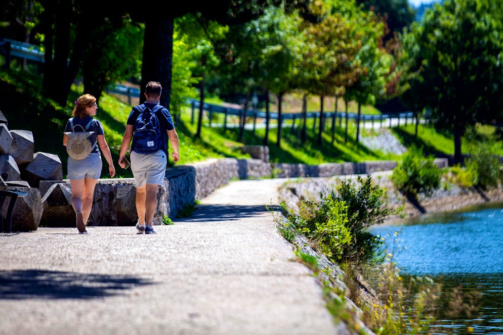 Des touristes marchent sur les rives du lac Bajer, près du village de Fuzine, en Croatie occidentale, le 30 juillet 2024.
