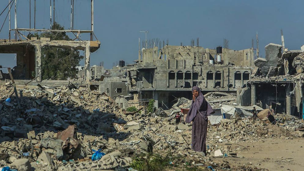 ARCHIV - Eine palästinensische Frau inspiziert die Überreste zerstörter Gebäude, während die Palästinenser in ihre Häuser zurückkehren, die durch die israelische Invasion in der Stadt weitgehend zerstört wurden. Foto: Abed Rahim Khatib/dpa