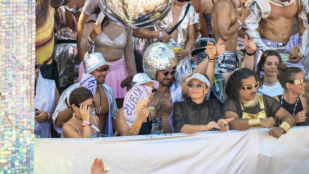 A raver wears a disco ball on his head.