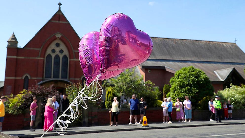 Heart-shaped balloons are like this as they take flight to the bluttat in Southport at St Patrick's Church nearby. Photo: Scott Heppell/AP/dpa