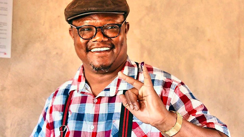 ARCHIVE - Tundu Lissu, then presidential candidate for the opposition Chadema party, smiles and shows his little finger marked with ink after casting his vote at a polling station in an elementary school. Photo: Uncredited/AP/dpa