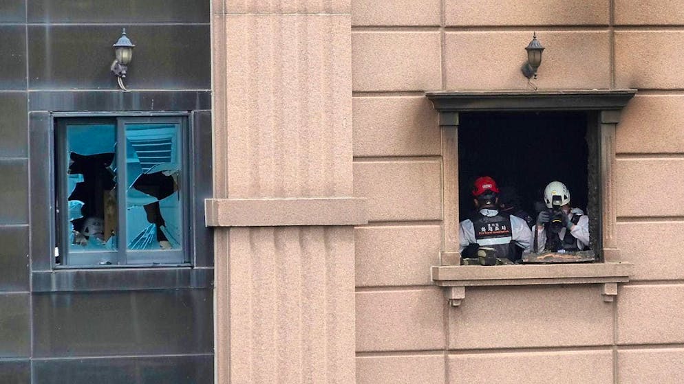 An investigation team examines the source of the fire. Photo: Ahn Young-joon/AP