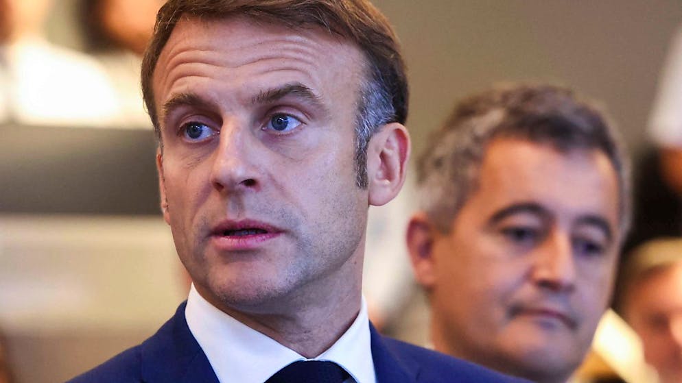 Il presidente francese Emmanuel Macron, dietro di lui il ministro dell'interno Gérald Darmanin