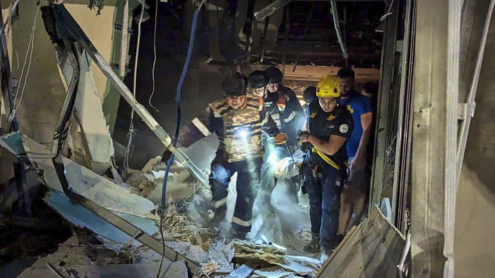 Soccorritori ucraini all'opera a Kryvyi Rih (città nella regione di Dnipropetrovsk, nell'est del paese) dopo l'esplosione di un missile russo la scorsa notte.