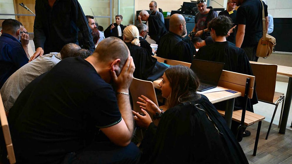 Mitangeklagte sprechen mit einer Anwältin (r) im Gerichtsgebäude während des Prozesses. Foto: Christophe Simon/AFP/dpa