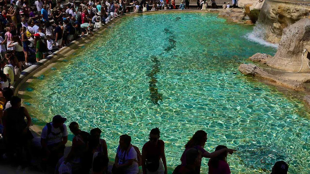 ARCHIVE - Tourists cool off at the Trevi Fountain. Photo: Gregorio Borgia/AP/dpa