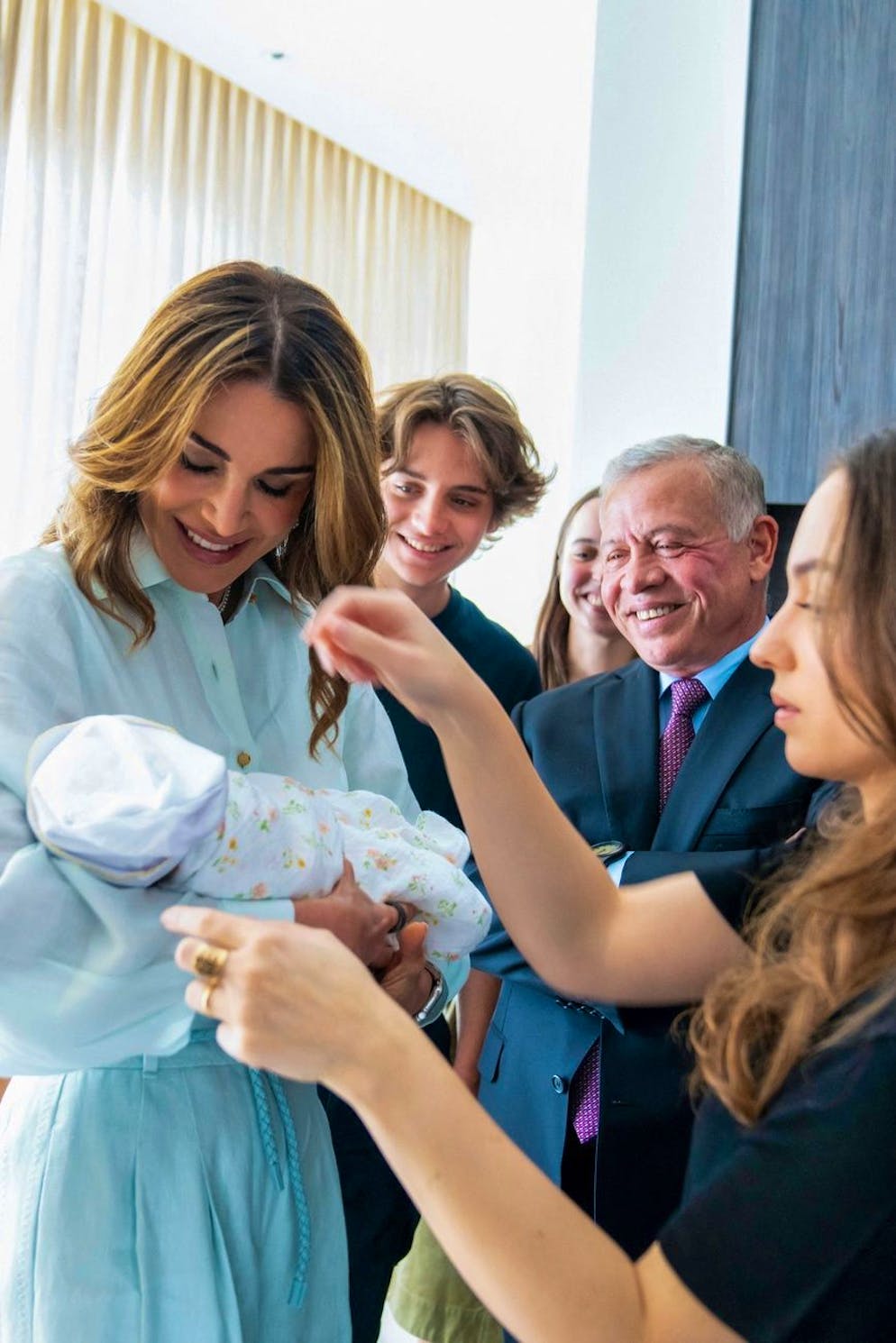La reine Rania de Jordanie, mamie stylée. Pour la rencontre avec sa petite-fille Iman, le 3 août 2024, elle était apprêtée comme à son habitude, vêtue d'une robe-chemise bleu clair.