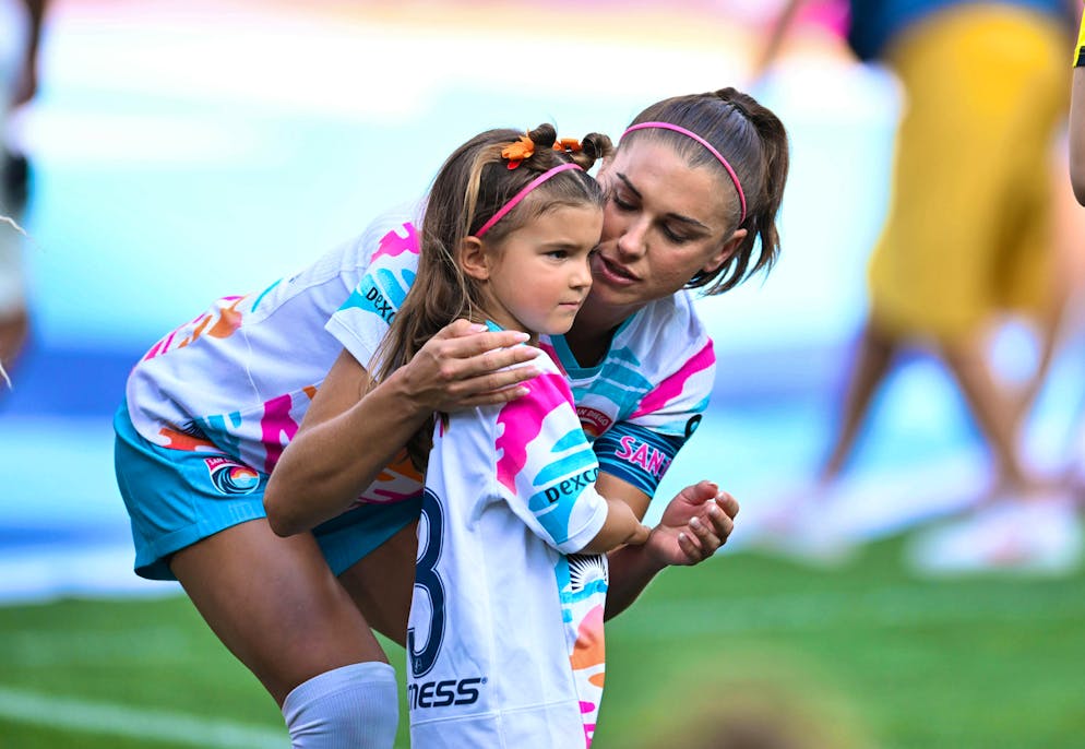 Alex Morgan is accompanied onto the pitch by daughter Charlie Carrasco before her last game.