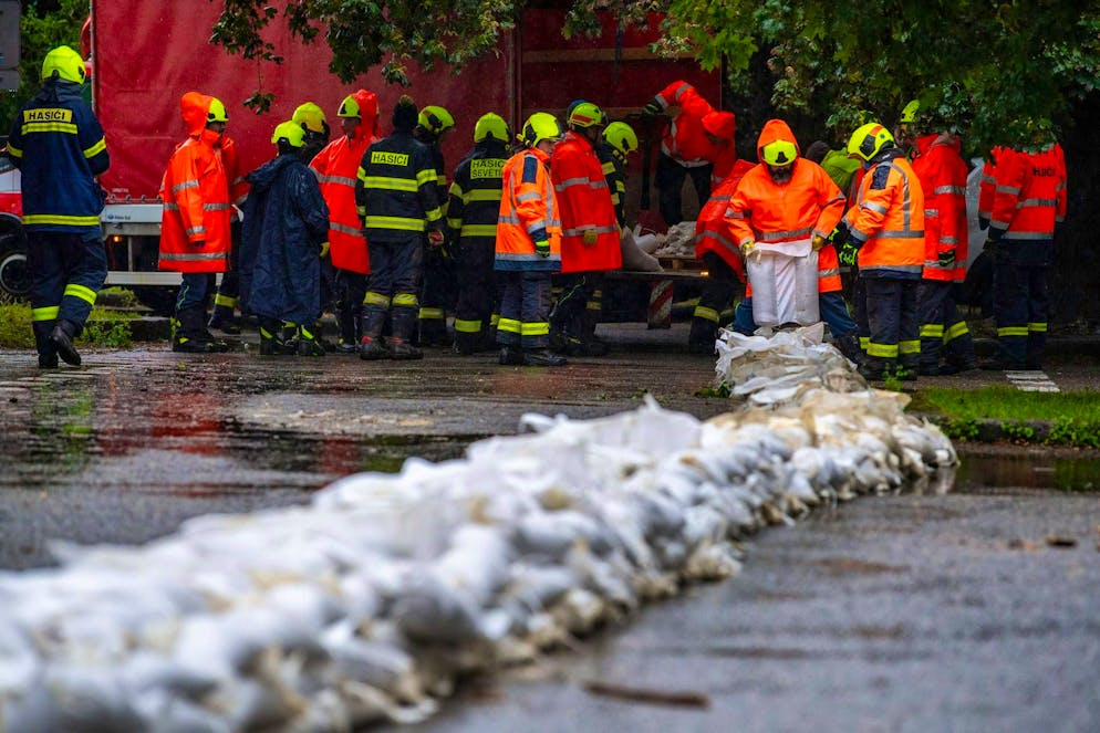 Firefighters work on a flood barrier with sandbags. The Czech Republic is expecting heavy rainfall in the near future, which could lead to high water and flooding.