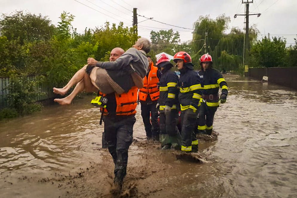 Sur cette photo publiée par les services d'urgence roumains de Galati (ISU Galati), un sauveteur porte un vieil homme à Pechea, en Roumanie, le samedi 14 septembre 2024, après que des pluies torrentielles aient laissé des dizaines de personnes bloquées dans des zones inondées. (Services d'urgence roumains - ISU Galati via AP)