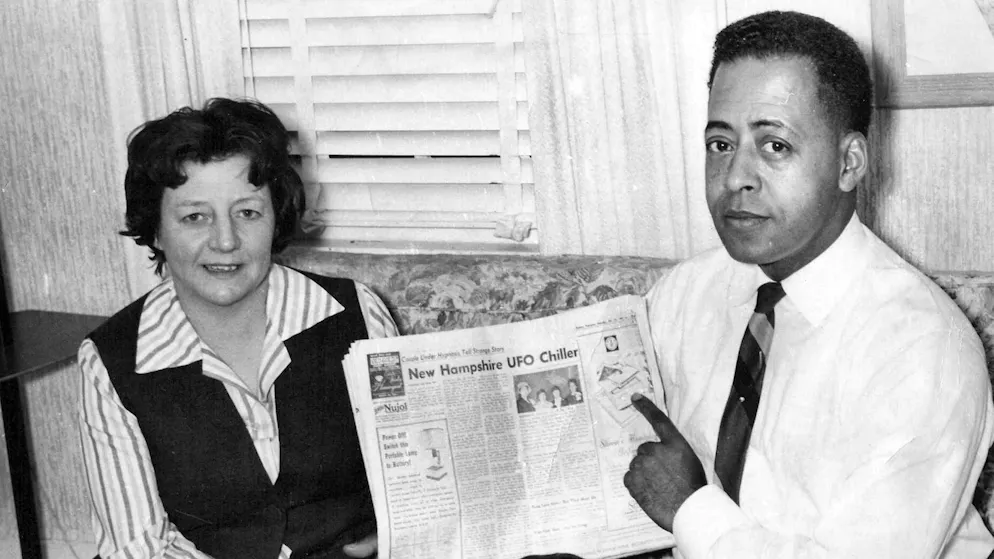 Barney and Betty Hill pose with a newspaper article recounting their experience.