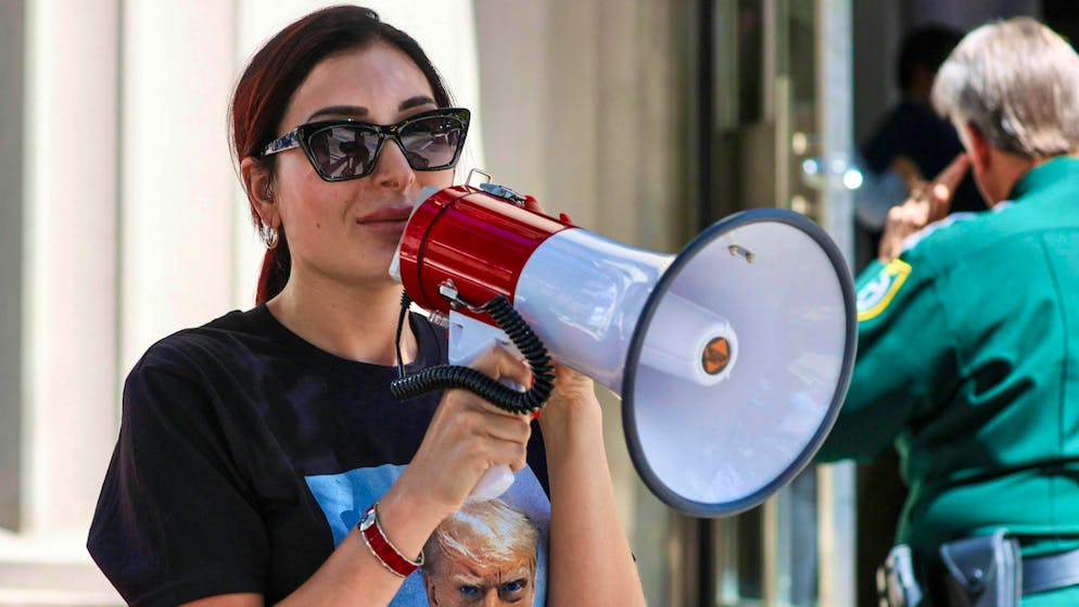 Sostenitrice particolare. Chi è la donna razzista e complottista accanto a Trump?