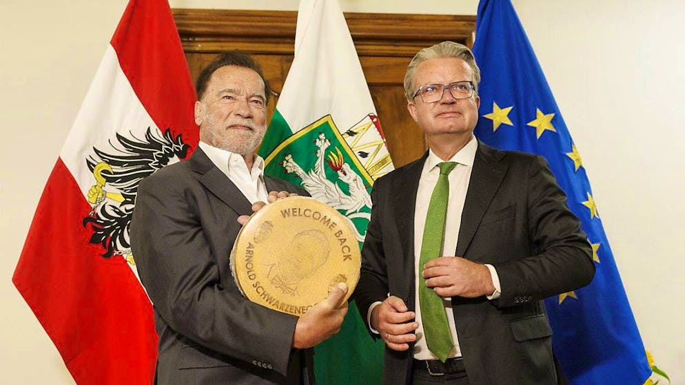 Arnold Schwarzenegger (l) receives a cheese from the Governor of Styria, Christopher Drexler (ÖVP) on the occasion of the presentation of a bust of former Governor Josef Krainer. Photo: Erwin Scheriau/APA/dpa