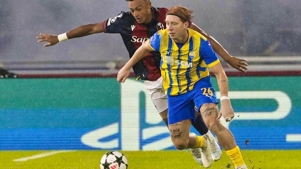 Dan Ndoye is shielded from the ball by Shakhtar's Yukhym Konoplya