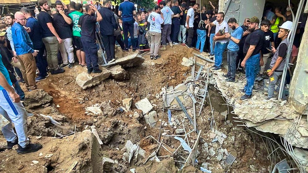People gather at the site of an Israeli missile strike in the southern suburbs of Beirut. Photo: Bilal Hussein/AP