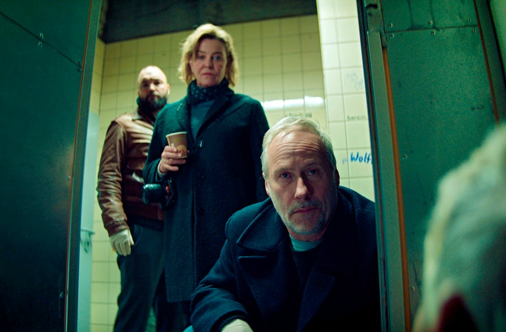 Das sind die Easter Eggs aus dem Psycho-Tatort. Die Ermittler Anna Janneke (Margarita Broich), Paul Brix (Wolfram Koch, rechts) und Assistent Jonas Hauck (Isaak Dentler) finden einen Toten auf der Toilette, den sie als Informanten schätzten.